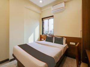 a bedroom with a large bed with a window at Super Collection O SRP LUXURY ROOMS in Hyderabad