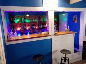 um bar com dois bancos em frente a uma parede azul em Habitación en villa neo victoriana con piscina em Mar del Plata