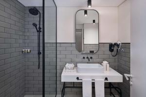 a bathroom with a white sink and a shower at The Manor By JA in Dubai