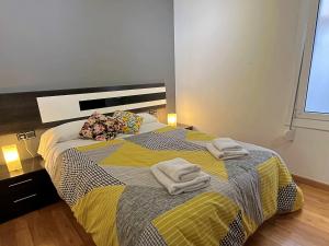 a bedroom with a large bed with towels on it at Apartamento cerca de la playa in Blanes