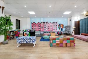 a room with couches and a mural of a building at House of Backpackers in Jaipur