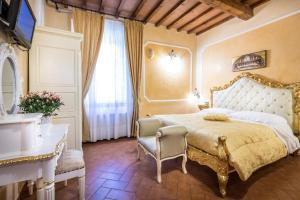 a bedroom with a bed and a desk and a window at Soggiorno Annamaria in Florence