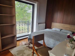 a bedroom with a bed and a table and a window at Villa in Trilofos-close to the beach in Thessaloniki