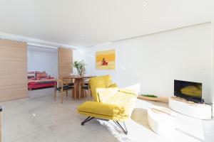 een woonkamer met een gele stoel en een tafel bij L'Aiglon By SCLS Locations in Vallauris