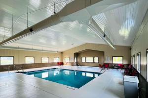 ein großer Pool in einem Gebäude mit roten Stühlen in der Unterkunft Sleep Inn & Suites in Wisconsin Dells