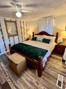 - une chambre avec un grand lit et un ventilateur de plafond dans l'établissement Humble Cove Lake Cottage: kayaks, fishing, firepit, à Worthville