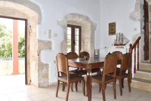 Arménoi的住宿－Madaro Traditional House，一间带木桌和椅子的用餐室