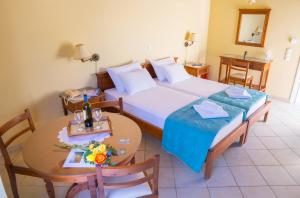 a hotel room with a bed and a table with a table at Olive Τrees Garden in Lixouri