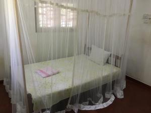 a bedroom with a bed with curtains and a window at Mango villa in Unawatuna