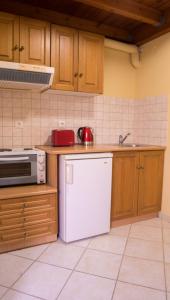 La cuisine est équipée d'un réfrigérateur blanc et d'un four micro-ondes. dans l'établissement Olive Τrees Garden, à Lixouri