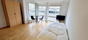 Apartments EFDE GmbH في هايلبرون: غرفة نوم بسرير وطاولة وكراسي