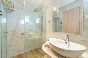 a bathroom with a sink and a glass shower at Lido Sofia Apartments in Agios Gordios