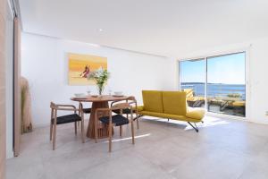 a living room with a table and a yellow chair at L'Aiglon By SCLS Locations in Vallauris