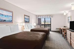 a hotel room with two beds and a television at Columbia River Hotel, Ascend Hotel Collection in The Dalles in The Dalles