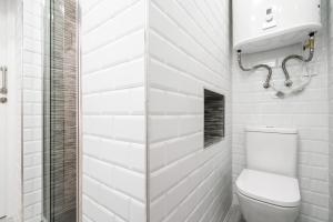 a white bathroom with a toilet and a shower at Chueca San Antón Apartment in Madrid
