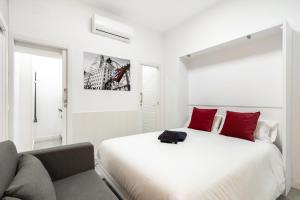 a white bedroom with a large bed and a couch at Chueca San Antón Apartment in Madrid