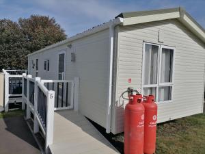 a white building with two red fire hydrants next to it at Kent Coast Holiday Park in Rochester