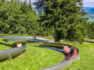 ゲルスフェルトにあるBerghotel Deutscher Flieger Wasserkuppeの公園内のプールで遊ぶ子供2名