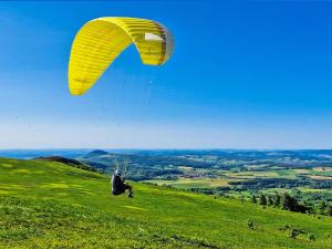 a person riding a parachute on a grassy hill at Berghotel Deutscher Flieger Wasserkuppe in Gersfeld