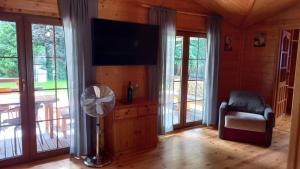 a living room with a flat screen tv and a fan at Andiland in Karwia