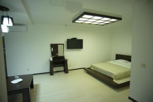 SEQUOIA boutique hotel في طراز: غرفة نوم مع سرير وتلفزيون على الحائط
