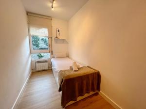 um pequeno quarto com uma cama e uma janela em Parc Güell 2 1 em Barcelona