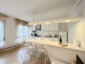uma cozinha com um balcão branco e algumas cadeiras em Parc Güell 2 1 em Barcelona