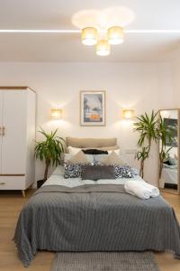 ein Schlafzimmer mit einem großen Bett und zwei Pflanzen in der Unterkunft C85Apartament KILO in Lublin