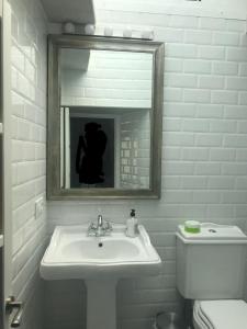 a bathroom with a sink and a mirror and a toilet at Casaimpecablecentro in Tarifa