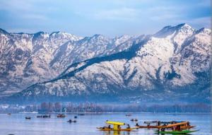 a group of boats in the water in front of mountains at B ,heritage luxury houseboat in Srinagar