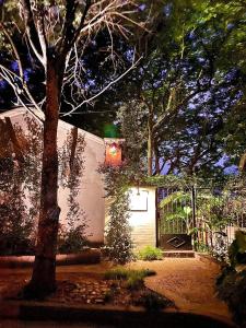 a white garage with a gate and a tree at Los Tarcos Guest House in San Salvador de Jujuy