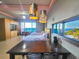 a bedroom with a bed and a table with a view of the ocean at OROJEJU in Seogwipo