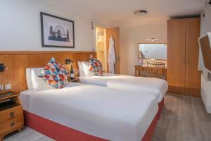 um quarto de hotel com duas camas e uma cozinha em Queensway Hotel, Sure Hotel Collection by Best Western em Londres