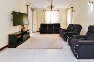 Una sala de estar con sofás y un televisor de pantalla plana. en Liya House, Nyali, en Mombasa
