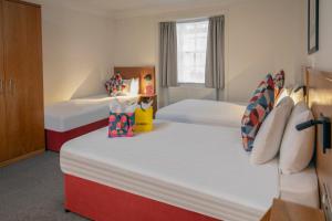 Cette chambre comprend 2 lits et une fenêtre. dans l'établissement Queensway Hotel, Sure Hotel Collection by Best Western, à Londres