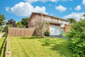 a brick house with a fence and a yard at Upscale 3BR/2.5BATH House +Games room and Yard! in Mississauga
