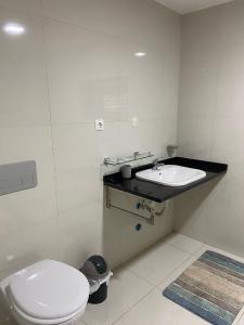 Baño blanco con aseo y lavamanos en NICE DUPLEX, PRAIA en Praia