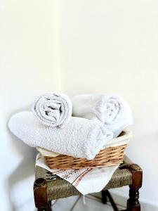 uma cesta cheia de toalhas numa cadeira em Patras Rooms em Fourni Ikarias