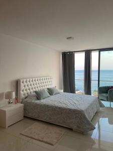 1 dormitorio con cama y vistas al océano en NICE DUPLEX, PRAIA, en Praia