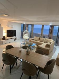 ein Wohnzimmer mit einem Sofa, einem Tisch und Stühlen in der Unterkunft NICE DUPLEX, PRAIA in Praia
