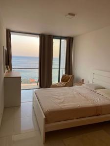 a bedroom with a bed and a view of the ocean at NICE DUPLEX, PRAIA in Praia