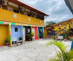 a building with a mural on the side of it at Pousada Maria Bonita Abreu e Lima in Maricota