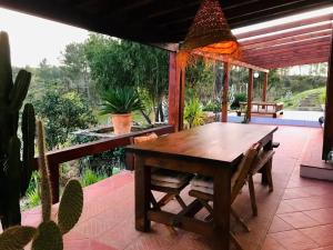 a wooden table and chairs on a patio with cactus at Stunning fazenda w/ beautiful pool and privacy 