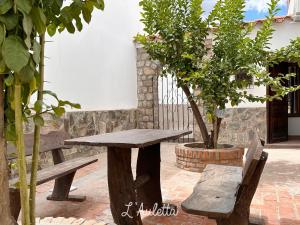 una mesa de picnic y un banco en un patio en L' Auletta en Cafayate