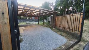 an entrance to a fence with a wooden pergola at Casa Huedhued in Villarrica +12 photos