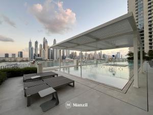 a pavilion with a table and a pool in a city at Manzil - 1BR Apartment in Emaar Beachfront with Private Beach & Marina Access in Dubai