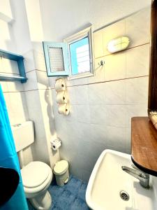 Łazienka z białą toaletą i umywalką w obiekcie Patras Rooms est 1990 w mieście Fourni Ikarias