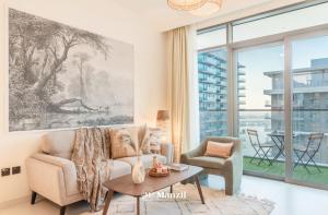 a living room with a couch and a table at Manzil - 1BR Apartment in Emaar Beachfront with Private Beach & Marina Access in Dubai