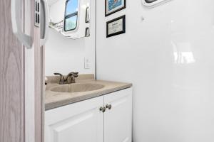 a bathroom with a sink and a refrigerator at Treasure Harbor in Islamorada