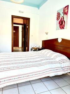 a bedroom with a large bed with a wooden headboard at Patras Rooms est 1990 in Fourni Ikarias